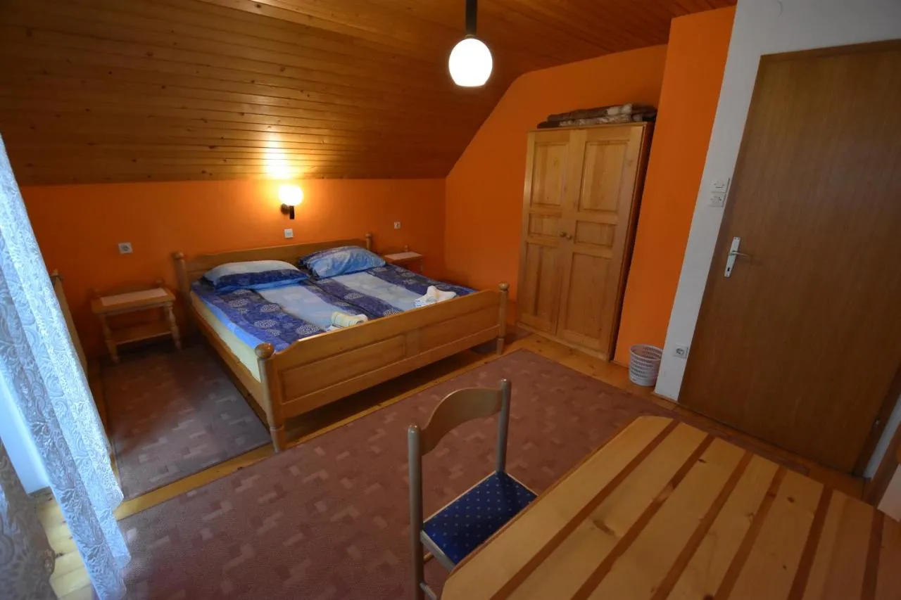 Spalnica z oranžno steno in zakonsko posteljo