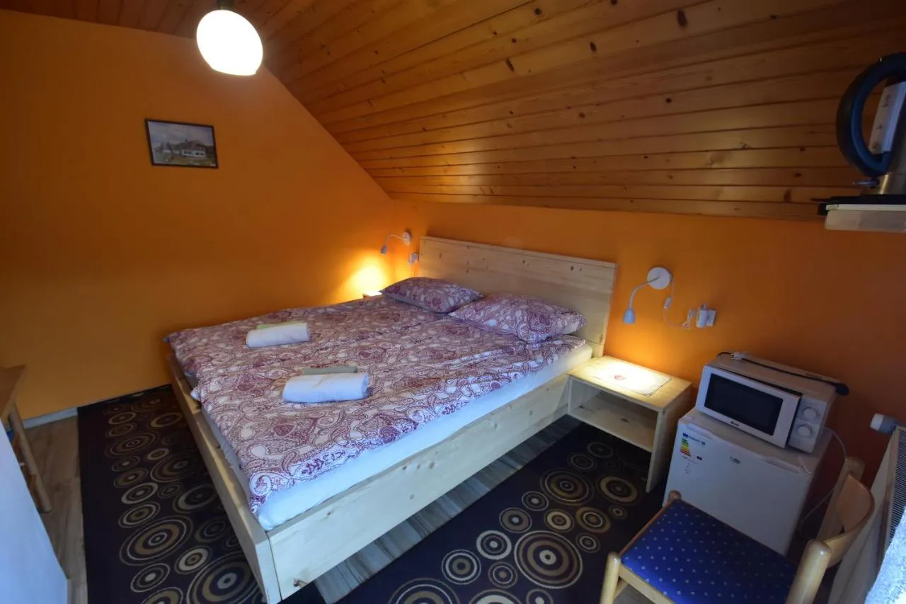 Postelja in nočni omarici pod poševnim stropom
